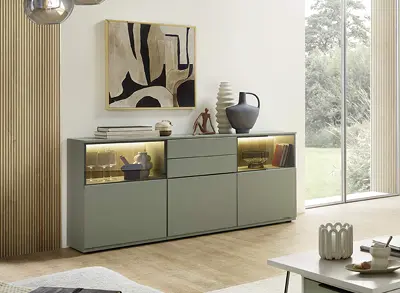 Helles Sideboard mit beleuchteten Fächern, Vase, Wandbild und Fensterfront rechts